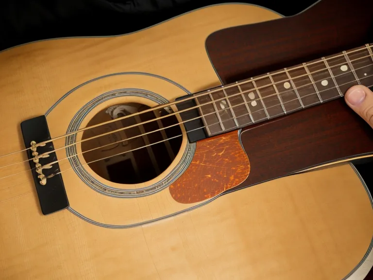 Guitarrista adulto principiante estirando la mano cansada después de tocar guitarra acústica