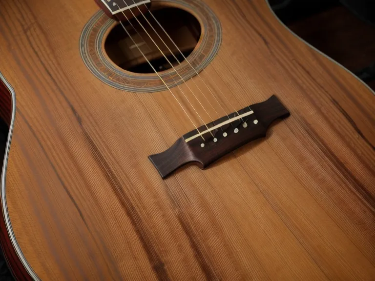 Independencia de los dedos en acordes de guitarra acústica: manos de un adulto practicando de noche en casa