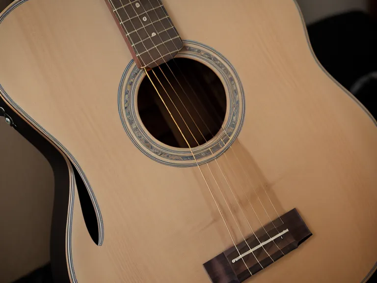 Paño de microfibra limpiando la suciedad de las cuerdas metálicas de una guitarra