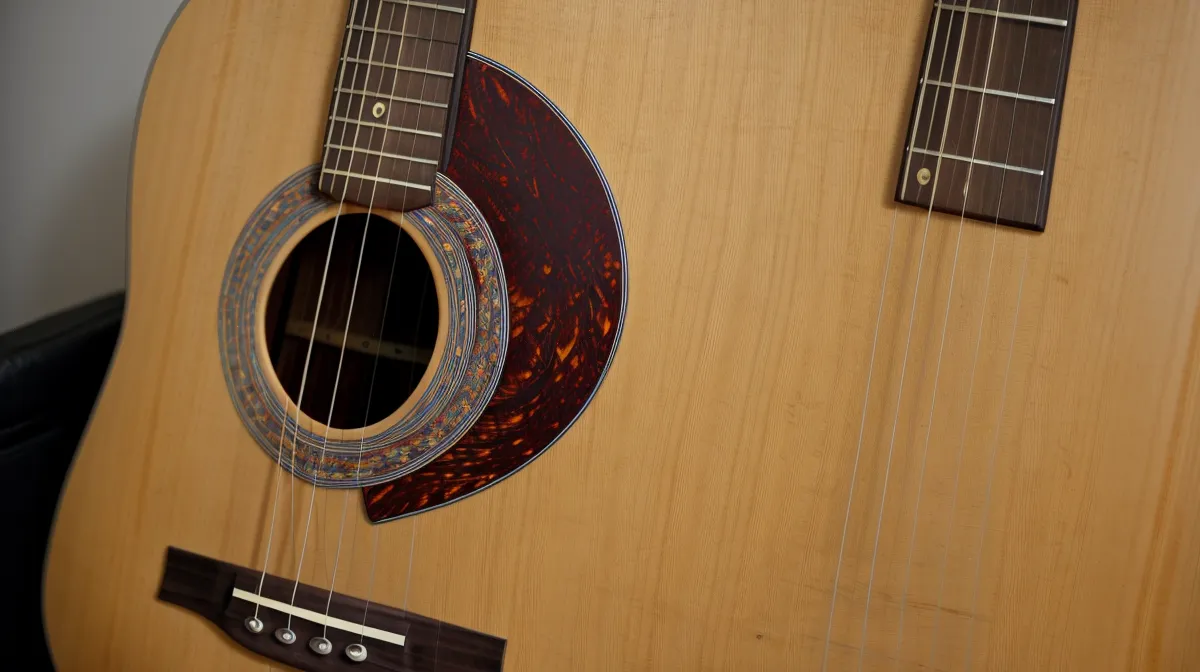 Guitarra acústica en una sala a oscuras, practicando en silencio para no despertar a la familia