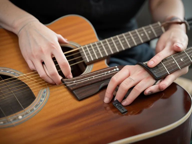 Metrónomo lento marcando el paso durante ejercicios de coordinación mano derecha e izquierda en guitarra.
