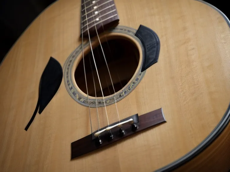 Mano rasgueando suavemente una guitarra acústica al practicar ritmo para alabanzas