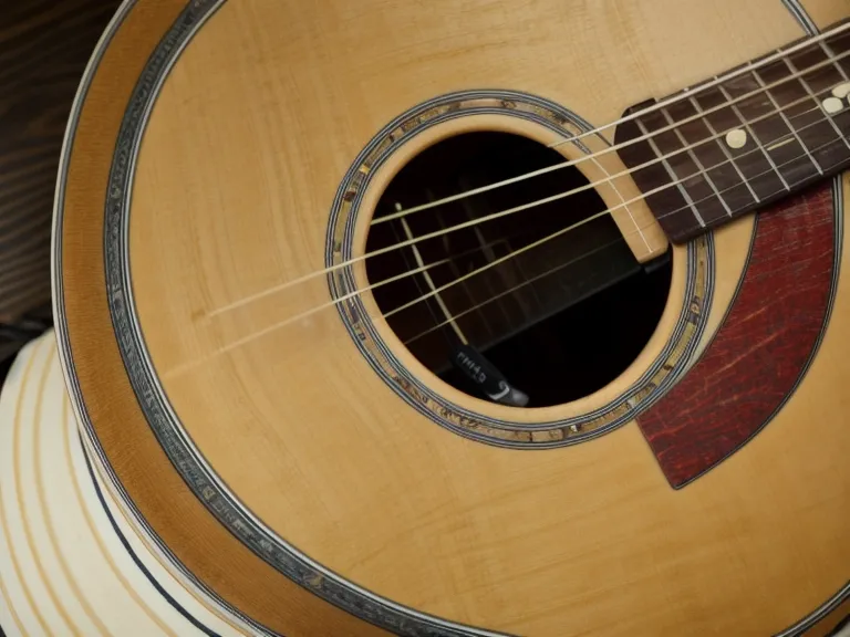 Manos cansadas del trabajo diario descansando junto a una guitarra acústica antes de practicar